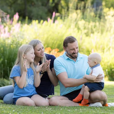 Familienfotos Fotograf: Familie mit zwei Kindern auf der Parkwiese. Fotograf Fotoshooting.