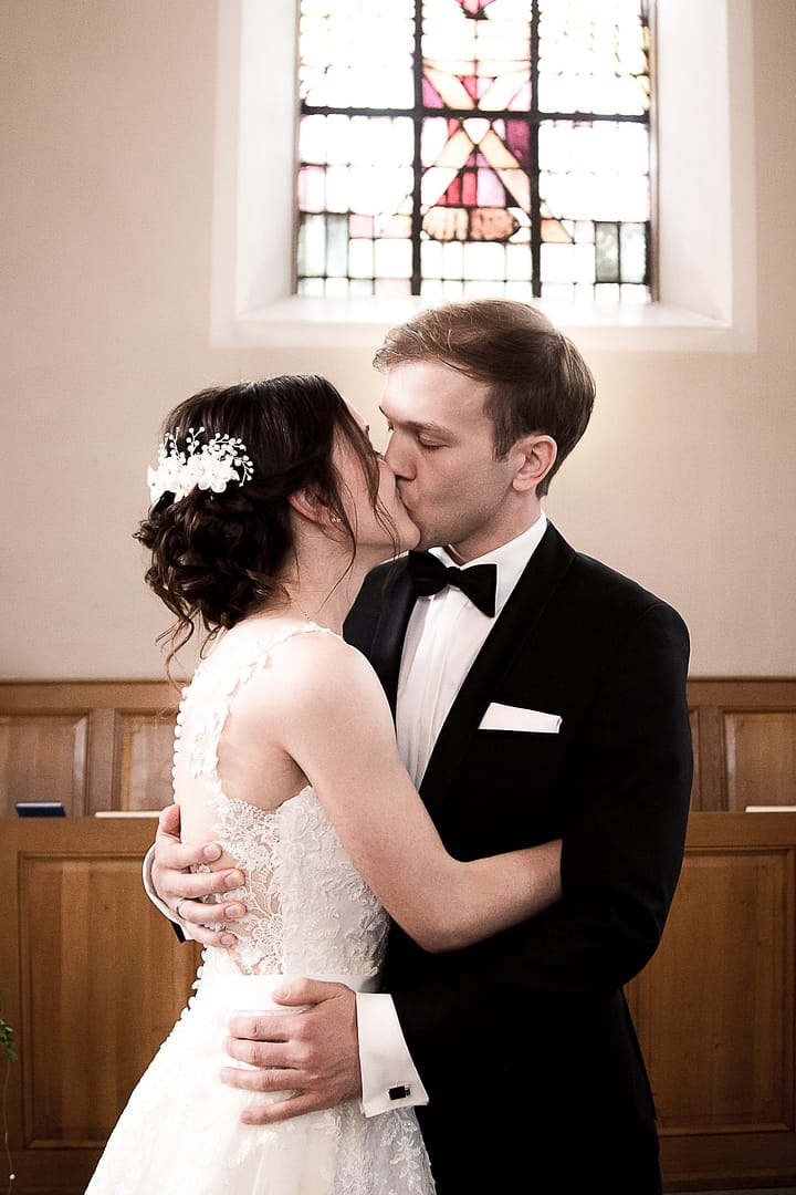 Die Braut und der Bräutigam küssen sich, während sie sich umarmen.